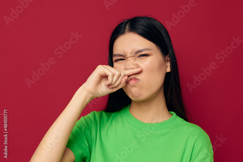 pretty brunette green t-shirt gestures with his hands red background unaltered