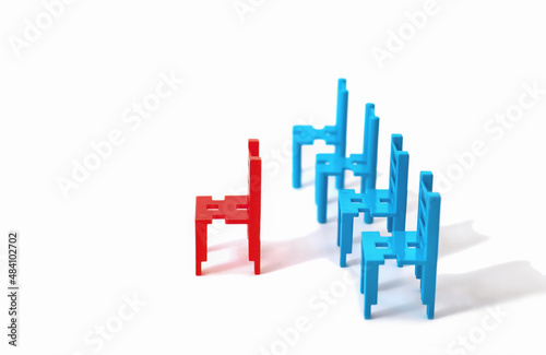 red and blue toy chairs isolated on white background. leadership concept. Standing Out From the Crowd. Asociality, sociopathy. Rejected from society, lonely. fear and misunderstanding photo