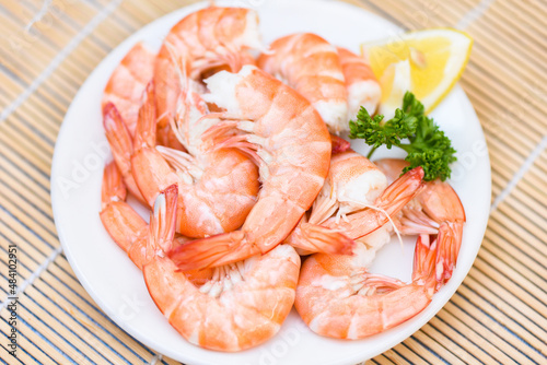 fresh shrimps served on white plate with parsley lemon , boiled peeled shrimp prawns cooked in the seafood restaurant