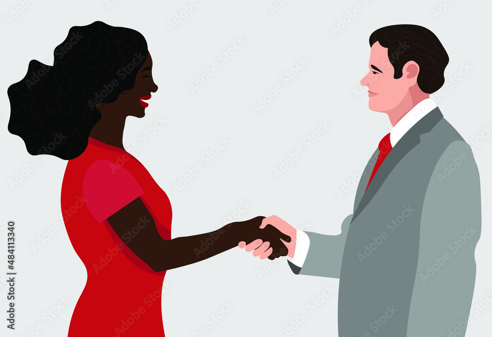 A woman and a man in the office shake hands.