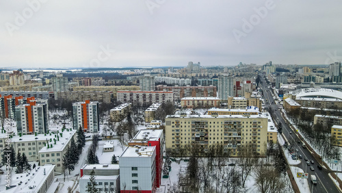 Aerial view of houses and road in the large city. Winter landscape. Residential areas in central of Minsk in the snow.
