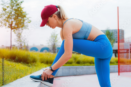 Fotografi Fit happy confident woman in sportswear doing stretching by throwing leg on conc