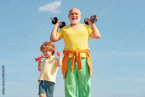 Grandfather and son doing exercises. Active family enjoy sport and fitness. Father and son build biceps and triceps. Senior man workout in rehabilitation center.