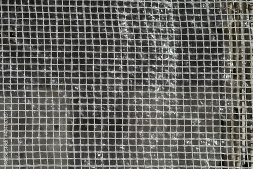 Texture of plastic mesh. Squares of white threads. Selective foc