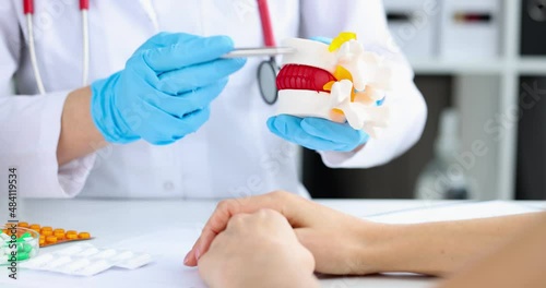 Doctor shows vertebral hernia to patient on model closeup