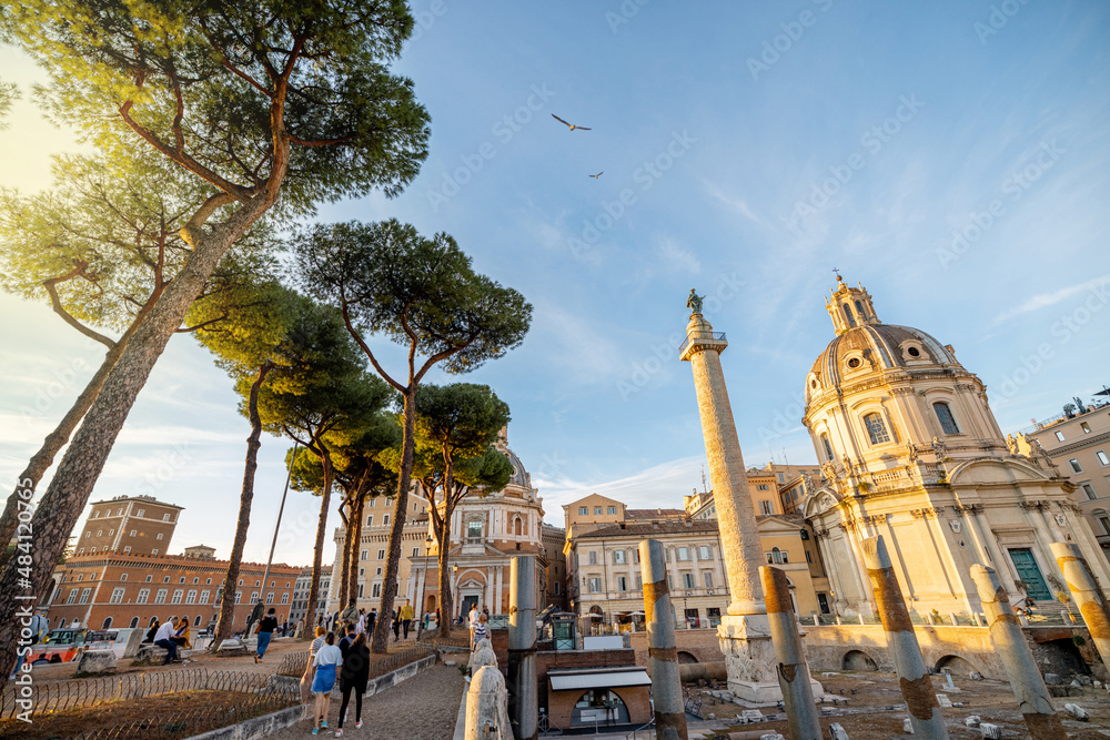 Ruins of Roman forum with Trajan column and church of the Most Holy Name of Mary. Rome cityscape on sunset. Concept of historical landmarks and travel Italy