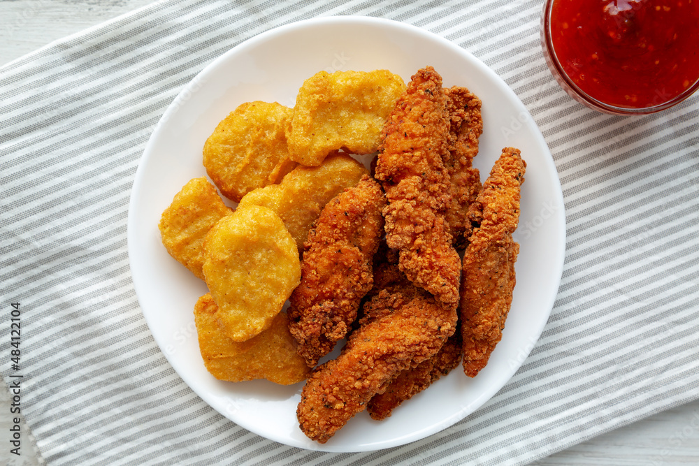 Homemade Nuggets and Chicken Tenders with Sweet and Sour Sauce, top view. Overhead, from above, flat lay. Homemade Nuggets and Chicken Tenders with Sweet and Sour Sauce, top view. Overhead, from above, flat lay.