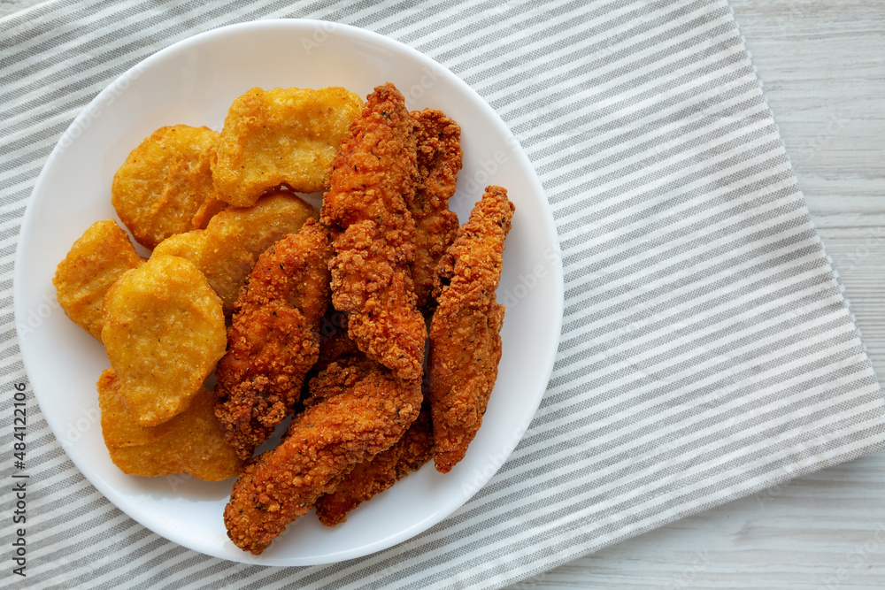 Homemade Nuggets and Chicken Tenders on a Plate, top view. Overhead, from above, flat lay. Copy space. Homemade Nuggets and Chicken Tenders on a Plate, top view. Overhead, from above, flat lay. Copy space.
