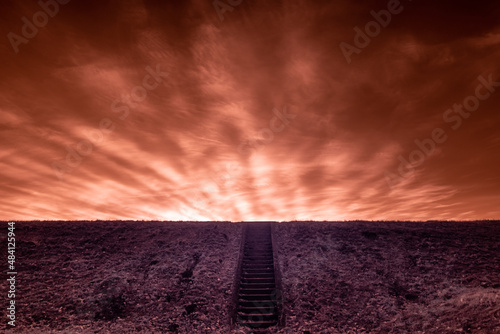 blask zachodzącego słońca na czerwonym niebie w nierealnym obrazie i schody prowadzące w górę