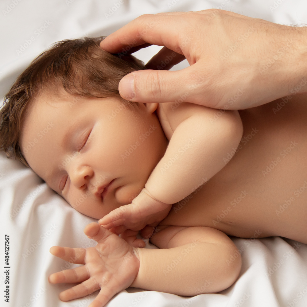 Small baby girl sleeping. Newborn baby in a wrap on white blanket. Beautiful portrait of little child girl 7 days, one week old. Baby lying on back on white background. Motherhood Small baby girl sleeping. Newborn baby in a wrap on white blanket. Beautiful portrait of little child girl 7 days, one week old. Baby lying on back on white background. Motherhood