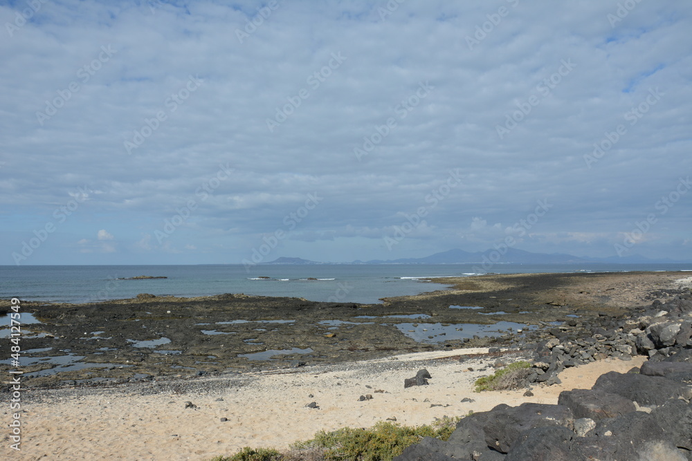 Bay full of volcanic stones in Bajo Ballena. El Cotillo La Oliva Fuerteventura Canary Islands. Bay full of volcanic stones in Bajo Ballena. El Cotillo La Oliva Fuerteventura Canary Islands.