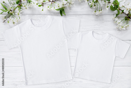 Two spring t-shirt mockup with blossom cherry, flat lay on wood background with copy space. Easter, Mothers day template. Mother and me