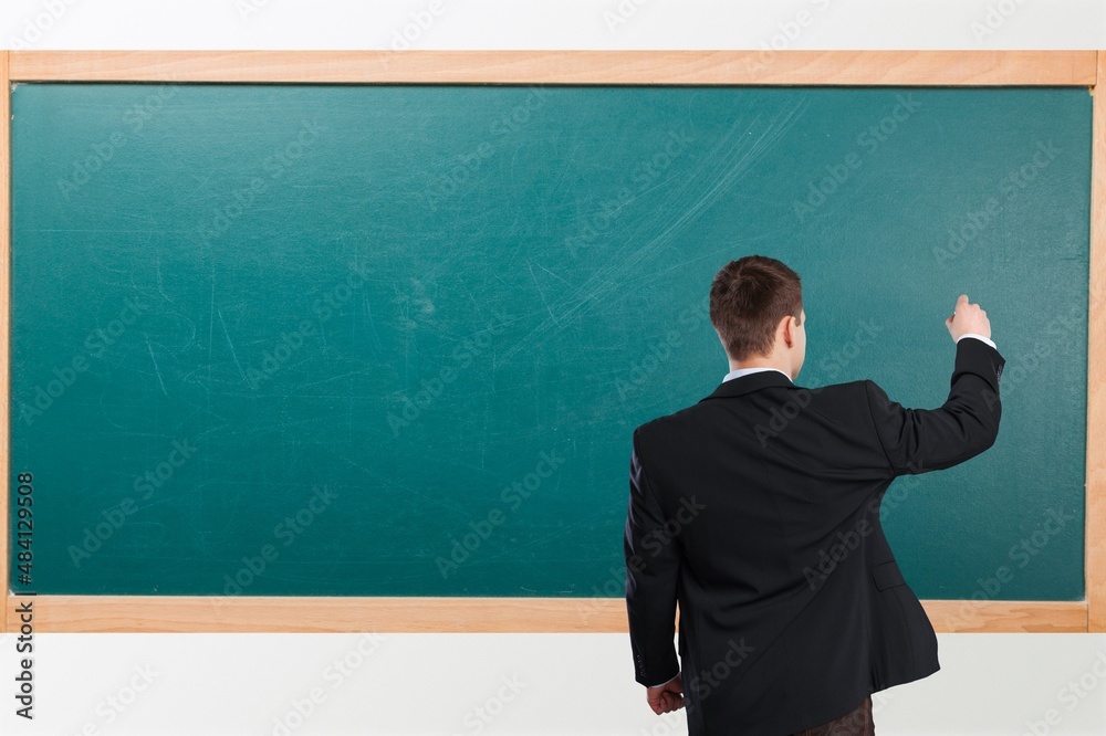 Student child writes with chalk on a blackboard solution of an example in mathematics. Student child writes with chalk on a blackboard solution of an example in mathematics.