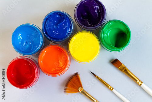 Wallpaper Mural A set of open jars with gouache in different colors and brushes on a gray background. Hobby - drawing. Top view. Torontodigital.ca