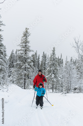 Young cross country skier in front of mother, Sweden.