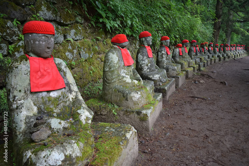 Statues of Ksitigarbha bodhisattva (Jizo) with red caps and bibs in Nikko, Japan
 photo