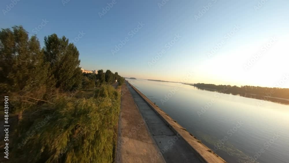 FPV drone flies over the city embankment at dawn FPV drone flies over the city embankment at dawn