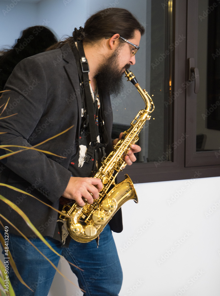 Naklejka premium young man playing saxophone