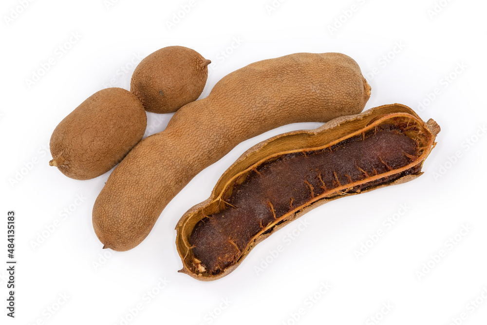 Whole ripe dry tamarind fruits and one partly peeled fruit Whole ripe dry tamarind fruits and one partly peeled fruit