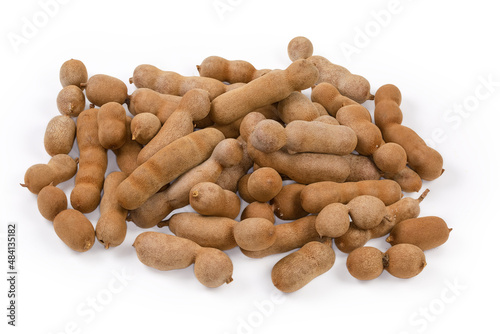 Heap of ripe dry whole tamarind fruits on white surface