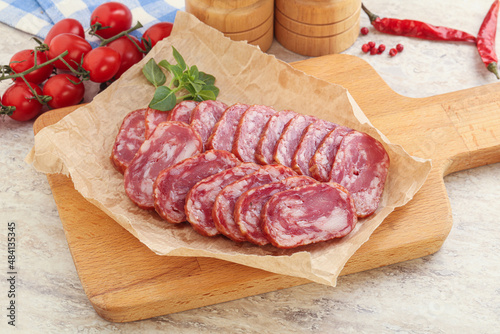 Sliced salami sausages over board