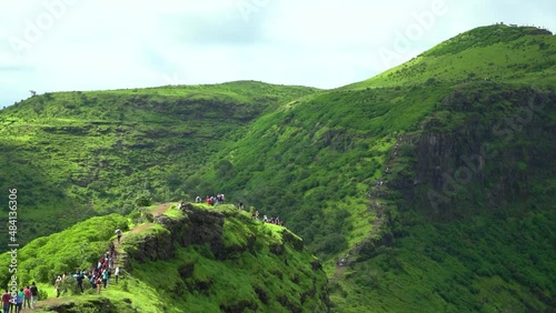 Wide angle shot of Governor hill at Saputara in Gujarat, India. Green hills of the Sahyadri mountain range during the monsoon. People trekking on the green hills of Saputara during their holidays.  photo