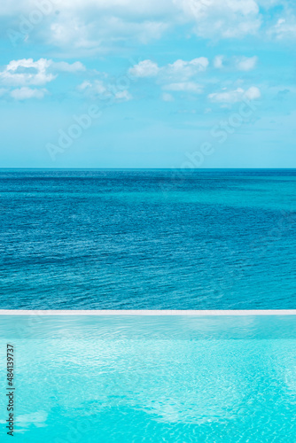 infinity pool at luxury hotel against ocean front, tropical resort. Relaxing, summer, travel, holiday, vacation and weekend concept