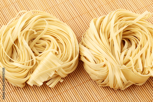 Italian pasta tagliatelle nest on white background 
