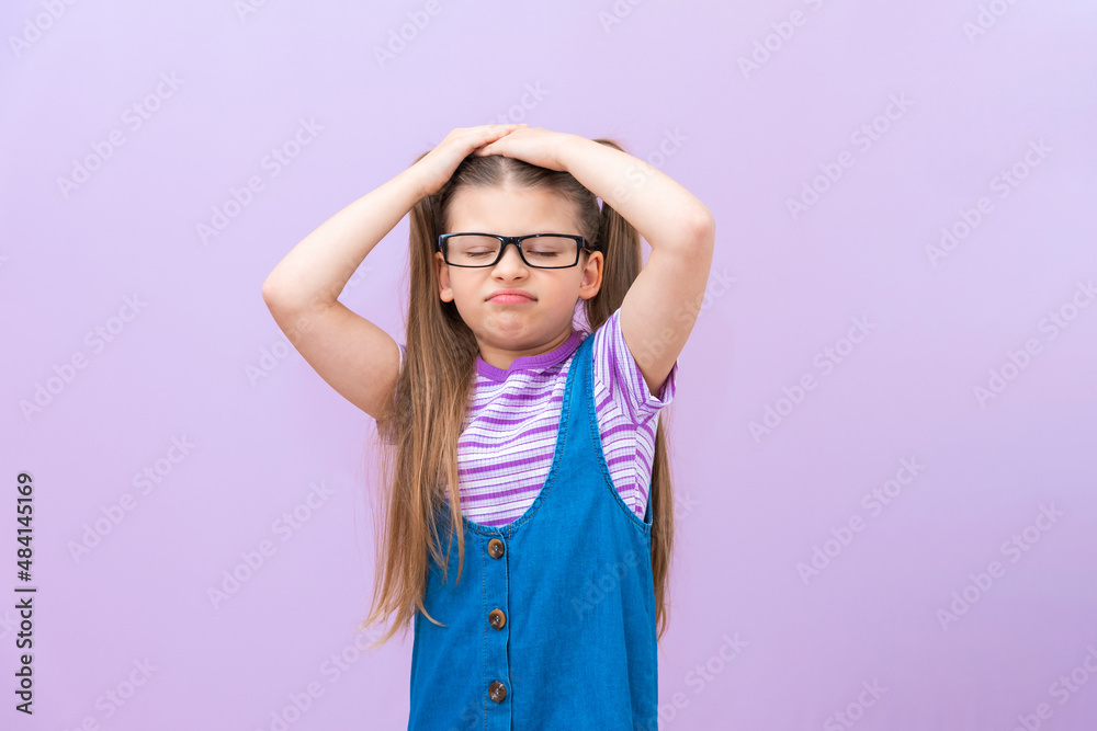 The outraged child holds his head with his hands and wrinkles his face and is mischievous. The outraged child holds his head with his hands and wrinkles his face and is mischievous.