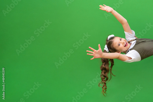 A little girl looks around the corner and smiles. The child is making faces around the corner.