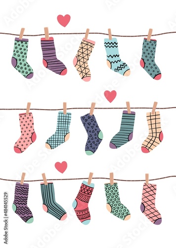 Funny socks in different colors hanging on ropes