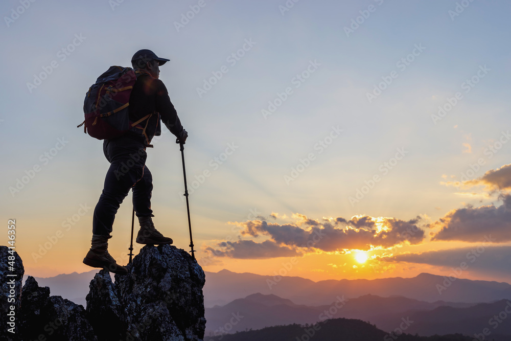 Silhouette Hiker standing on top mountain sunset background. Hiker men's hiking living healthy active lifestyle.