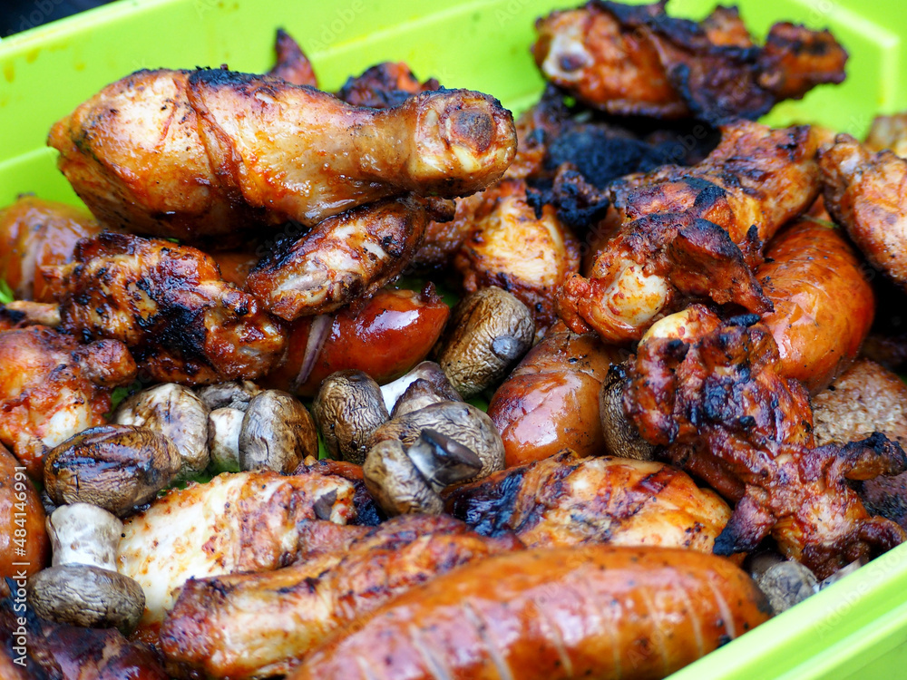 sausages, chicken wings and legs after the grill lies on a green plate sausages, chicken wings and legs after the grill lies on a green plate
