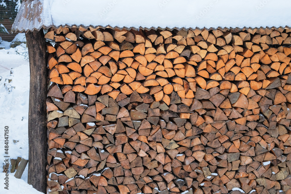 Firewood warehouse in the countryside. Firewood for the winter. Firewood outdoor storage, covered wooden logs stacked. Firewood warehouse in the countryside. Firewood for the winter. Firewood outdoor storage, covered wooden logs stacked.