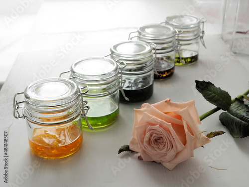 Organic extracts assorted in glass jars on light grey background. Selective focus.