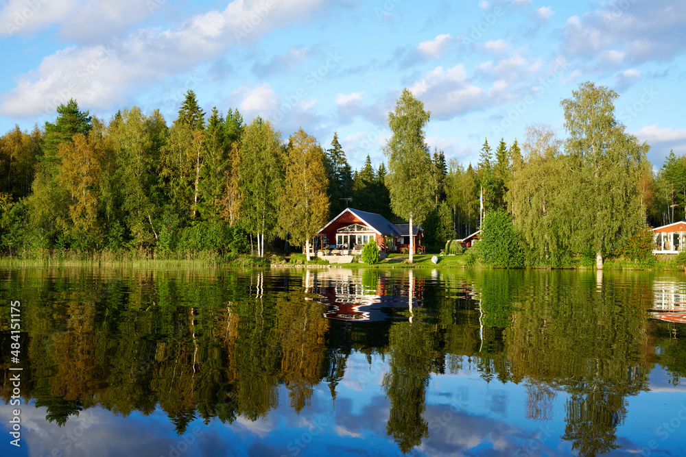 Wunderschöner Blick auf Stukas Ferienhäuser vom See aus in Schweden mit Spiegelungen im Wasser vom Boot aus Im Schwedenurlaub