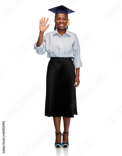 education, graduation and people concept - happy graduate student woman or bachelor in mortarboard waving hand over white background