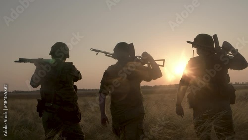 Group of soldiers in camouflage conducting complex military action on field.