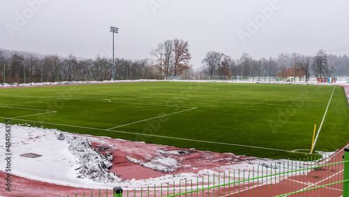 Soccer training field with artificial grass. Fallen snow on the treadmill