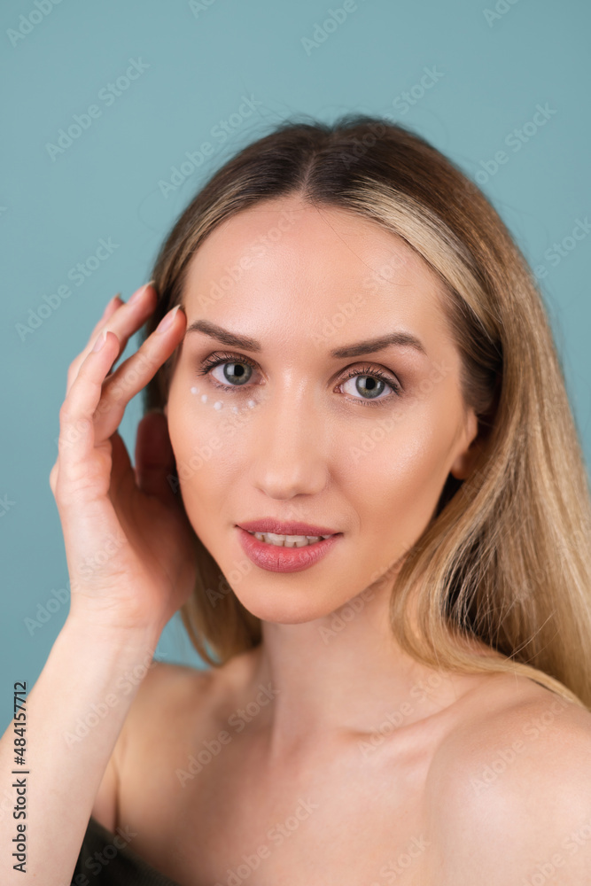 Close-up beauty portrait of a topless woman with perfect skin and natural make-up, with anti-aging cream dots to moisturize and firm the skin under the eyes. Close-up beauty portrait of a topless woman with perfect skin and natural make-up, with anti-aging cream dots to moisturize and firm the skin under the eyes.