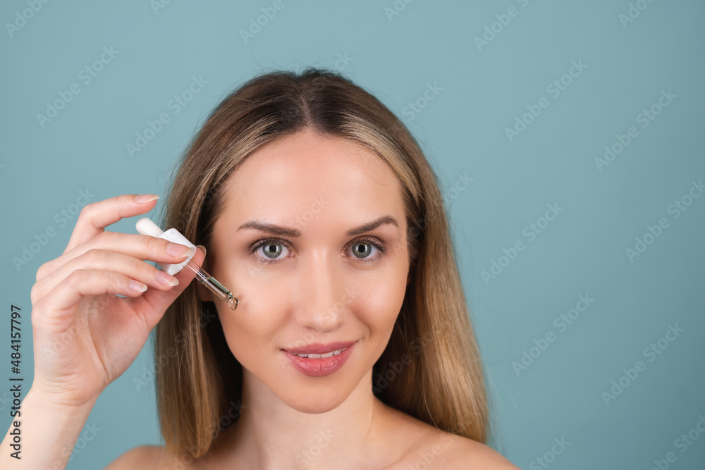 Close beauty portrait of topless woman with perfect skin and natural make-up, holds serum for youth and skin hydration, dropper with cosmetic oil. Close beauty portrait of topless woman with perfect skin and natural make-up, holds serum for youth and skin hydration, dropper with cosmetic oil.