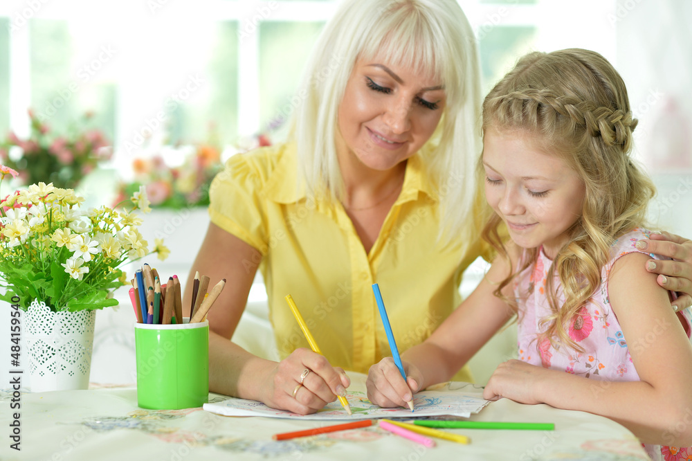 Beautiful mother and daughter drawing with her little girl Beautiful mother and daughter drawing with her little girl