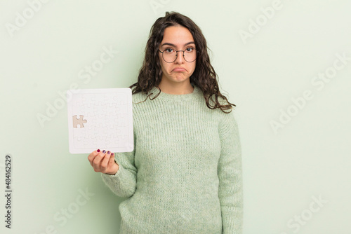 young pretty hispanic woman feeling sad and whiney with an unhappy look and crying. puzzle concept photo