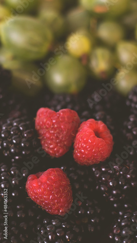 Summer fruity berry background. Table with berries and fruits. Summer breakfast, vacation, morning, sun. Berries, raspberries, blackberries, gooseberries. Vase with berries and fruits. 