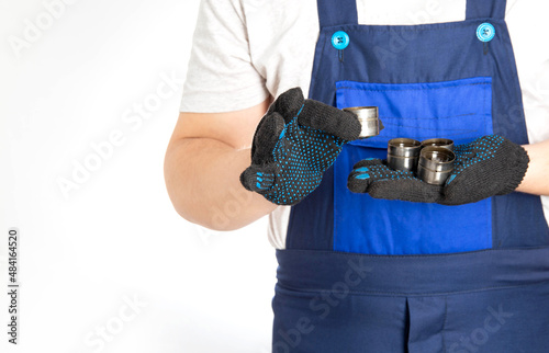 Auto mechanic minder holds in his hand automobile hydraulic lifters. Replacement of hydraulic lifters, malfunction of the lubrication system. Copy space for text