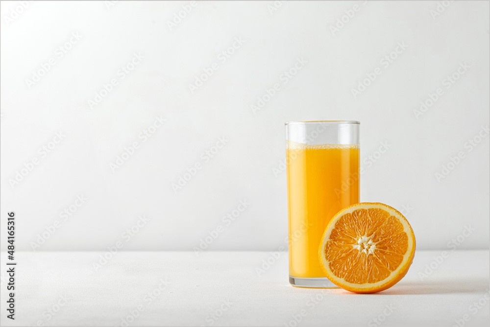 Orange juice for menu with ripe half of orange on white table. Copy space for text. Orange juice for menu with ripe half of orange on white table. Copy space for text.
