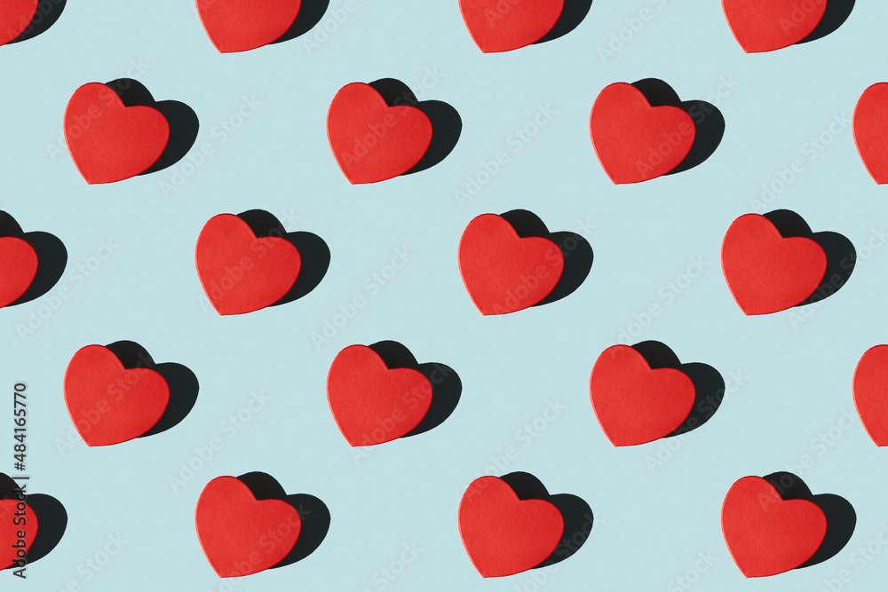 Paper red heart shape gift boxes pattern with shadows. Pattern of red heart shape gift boxes on a blue background with hard shadows. Valentine's card. Paper red heart shape gift boxes pattern with shadows. Pattern of red heart shape gift boxes on a blue background with hard shadows. Valentine's card.