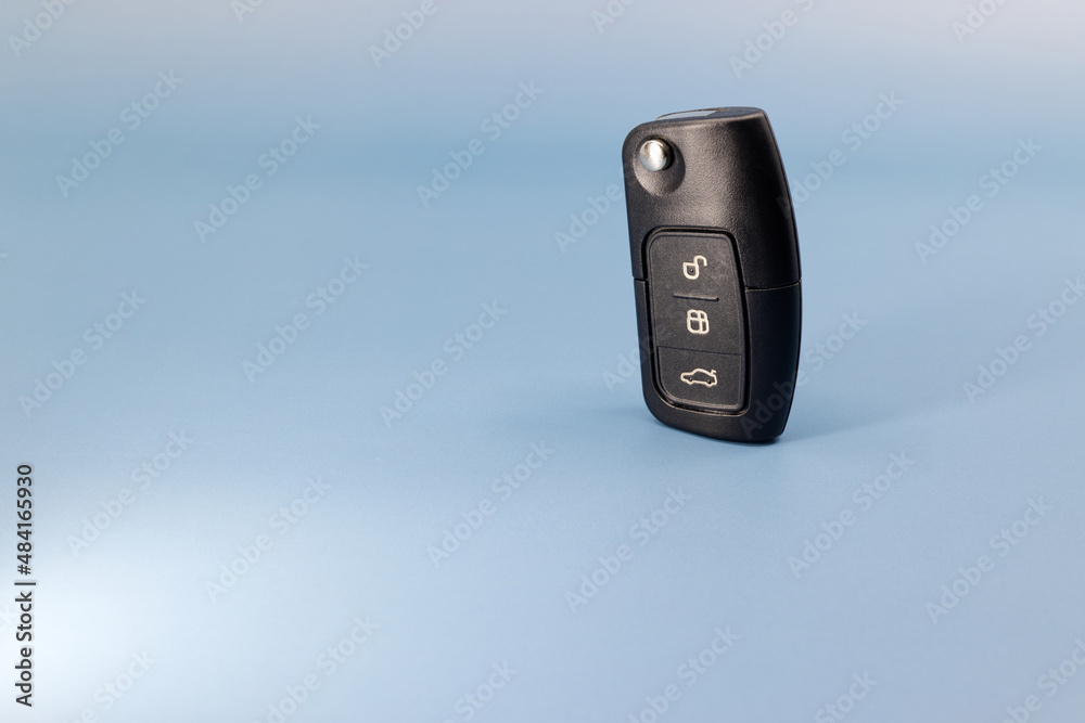 black electronic car key, blue background and table, studio shot, without people, a car as a gift black electronic car key, blue background and table, studio shot, without people, a car as a gift