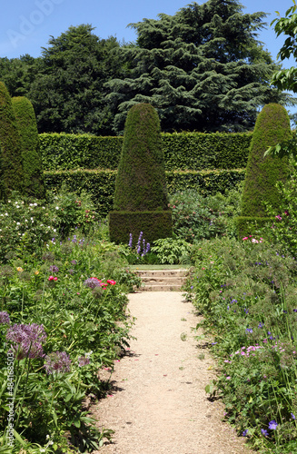 Sunlit garden path and flower borders. Gloucestershire England 