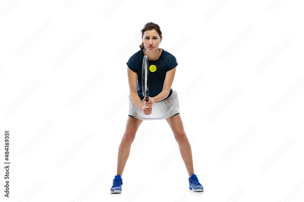 Dynamic portrait of young sportive woman, tennis player practicing isolated on white background. Healthy lifestyle, fitness, sport, exercise concept.